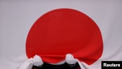 The Japanese national flag is seen before it flies at a medal ceremony dring the 2020 Olympics in Tokyo, Japan. 